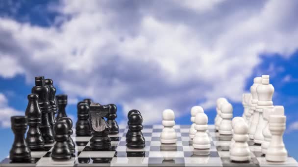 Una partida de ajedrez que se juega en stop motion con nubes pasajeras detrás - Metraje, vídeo