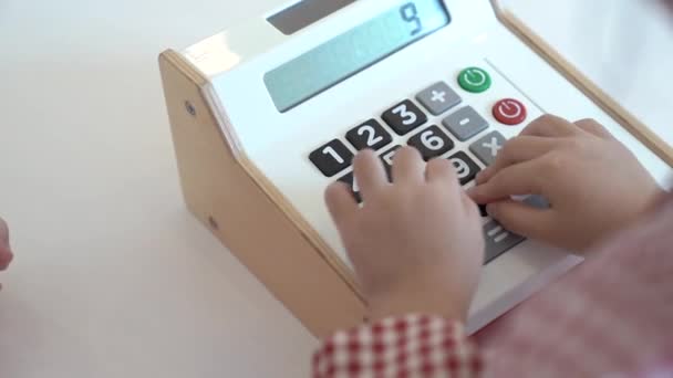 Kids are playing a wooden toy cash register by pressing the number nine and nine and nine. - Footage, Video