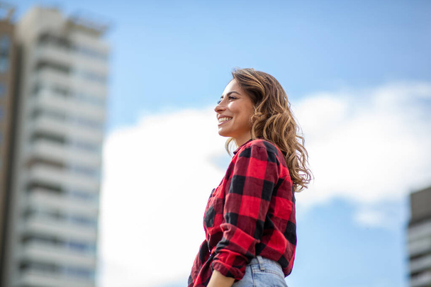 Πορτραίτο προφίλ νεαρής χαμογελαστής γυναίκας που στέκεται έξω  - Φωτογραφία, εικόνα