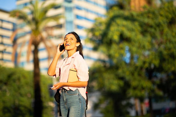 Portrét šťastné mladé ženy hovořící s mobilním telefonem ve městě  - Fotografie, Obrázek