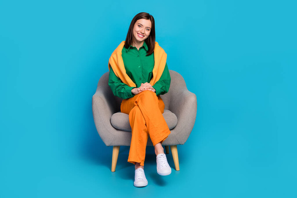 Full size photo of cheerful positive lady sit chair rest relax have good mood isolated on blue color background. - Photo, image