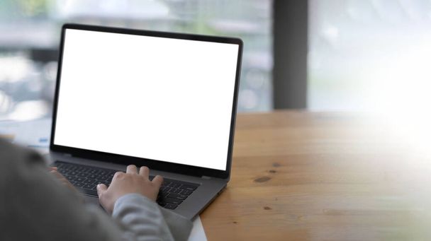 Image de maquette d'une femme utilisant et tapant sur un ordinateur portable avec écran de bureau blanc vierge sur une table en bois. - Photo, image