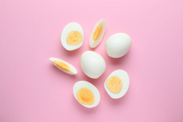 Fresh hard boiled eggs on pink background, flat lay - Foto, Imagen