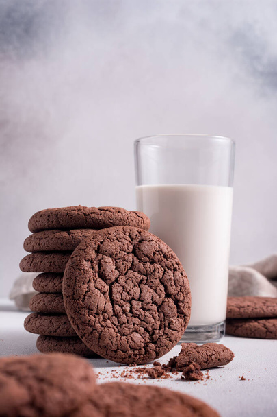 Domácí chutné americké čokoládové sušenky se sklenicí mléka na šedém betonovém pozadí - Fotografie, Obrázek