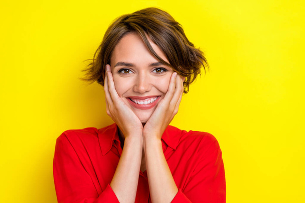Portrait of friendly satisfied girl beaming smile hands touch cheeks isolated on yellow color background. - Fotografie, Obrázek
