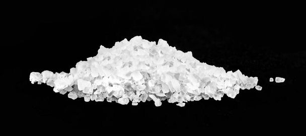 ένας σωρός από θαλασσινό αλάτι σε μαύρο φόντο.  - Φωτογραφία, εικόνα