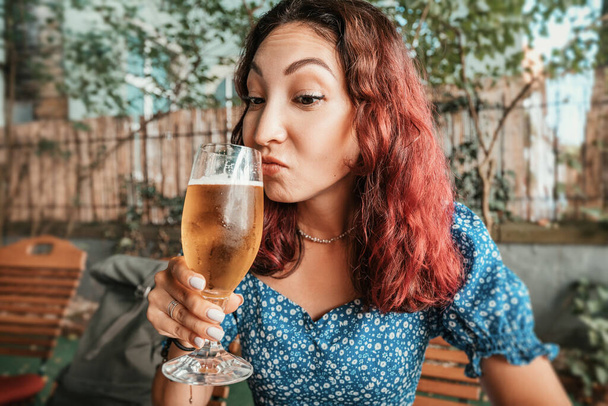 Una chica sommelier cerveza prueba el aroma de la cerveza de malta recién hecha en el bar - Foto, imagen