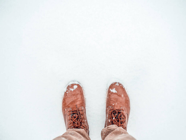 Tijd om winterschoenen te kopen. Top view man die in de sneeuw staat. Laarzen in pure sneeuw. Banner achtergrond met kopieerruimte. - Foto, afbeelding