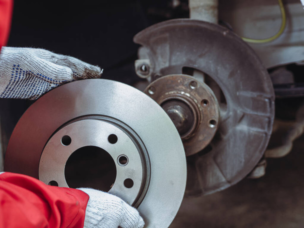 Process of replacing brake discs with Brand new. Auto mechanic repairing in garage Car brakes. - Photo, image