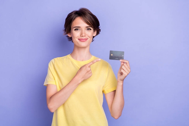 Photo of young attractive gorgeous nice woman wear yellow t-shirt finger pointing credit card user wireless payment new isolated on purple color background. - Foto, Bild