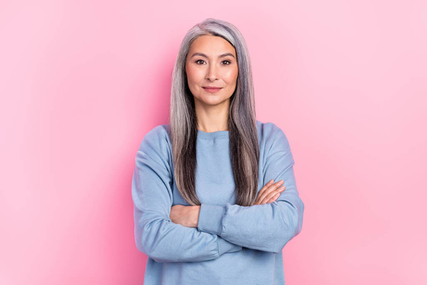 Photo of charming cute lady pensioner dressed blue pullover arms folded smiling isolated pink color background. - 写真・画像