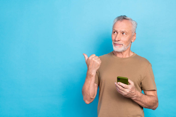 Photo of attractive retired man arm direct index empty space modern technology low price discount isolated on blue color background. - 写真・画像