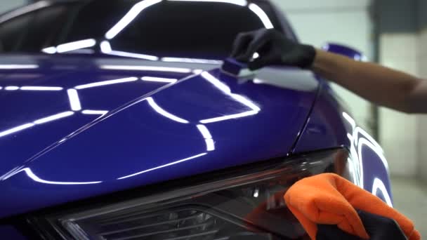 Applicazione a mano del cappotto protettivo nano ceramica per proteggere l'auto dai graffi. 4k processo video di applicare strato di ceramica sulla carrozzeria utilizzando spugna close-up in dettaglio servizio auto - Filmati, video