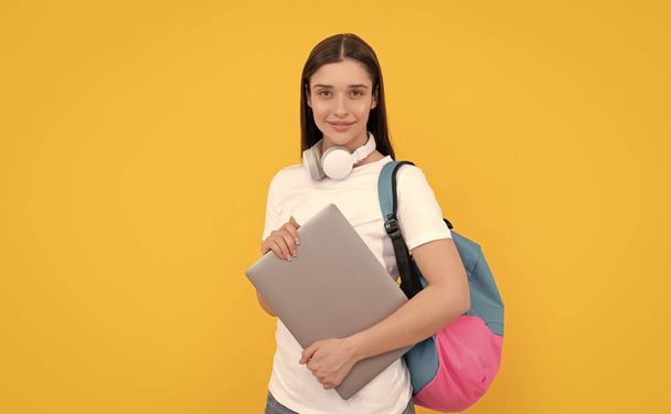 χαρούμενη κυρία στα ακουστικά κρατήστε το PC τσάντα μεταφοράς, σχολείο. - Φωτογραφία, εικόνα