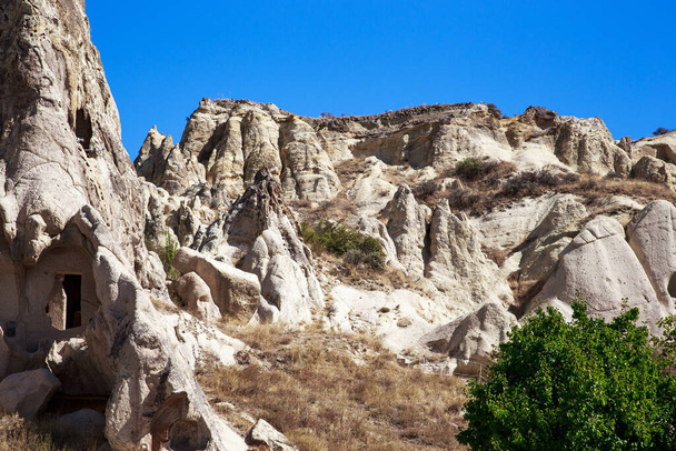 GOREME, TURKEY - 4 ΟΚΤΩΒΡΙΟΥ 2020: Πρόκειται για ογκώδεις βράχους ηφαιστειακής προέλευσης με κελιά σπηλαίων της παλαιοχριστιανικής μονής στο υπαίθριο μουσείο. - Φωτογραφία, εικόνα