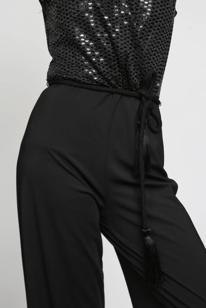 Serie studiofoto 's van vrouwelijk model in sprankelend zwart jumpsuit, eenvoudige en effectieve outfit voor oudejaarsfeest. Vakantie seizoen kleding. - Foto, afbeelding