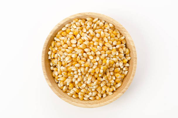 Ungeknallte Popcorn-Samen in Holzschale auf weißem Hintergrund.  - Foto, Bild