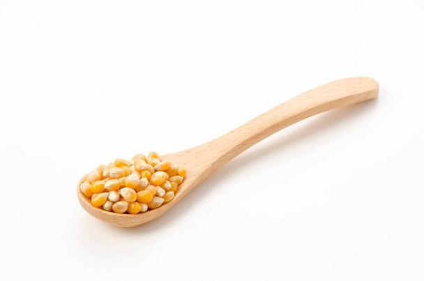 semillas de palomitas de maíz en cuchara de madera sobre fondo blanco - Foto, Imagen