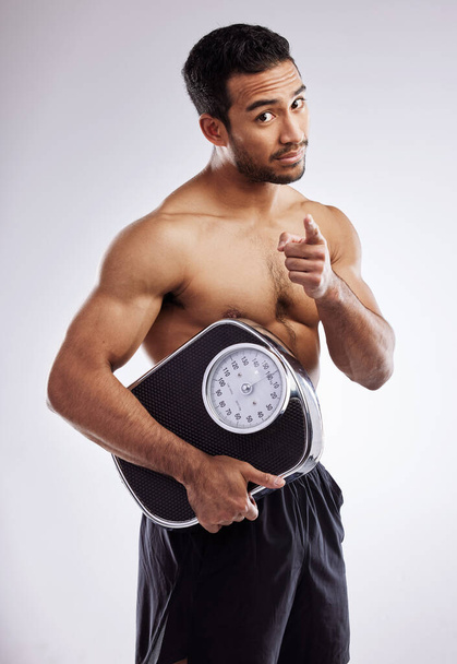 Dont let your goals fall by the wayside. a young man holding a scale against a studio background - Foto, Imagem
