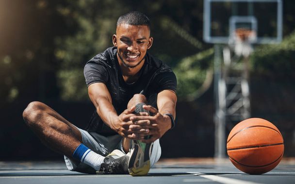Training, basketball player and man stretching legs in outdoor community court, muscle energy and healthy sports game performance. Happy, strong and young male athlete warm up exercise in competition. - Foto, immagini