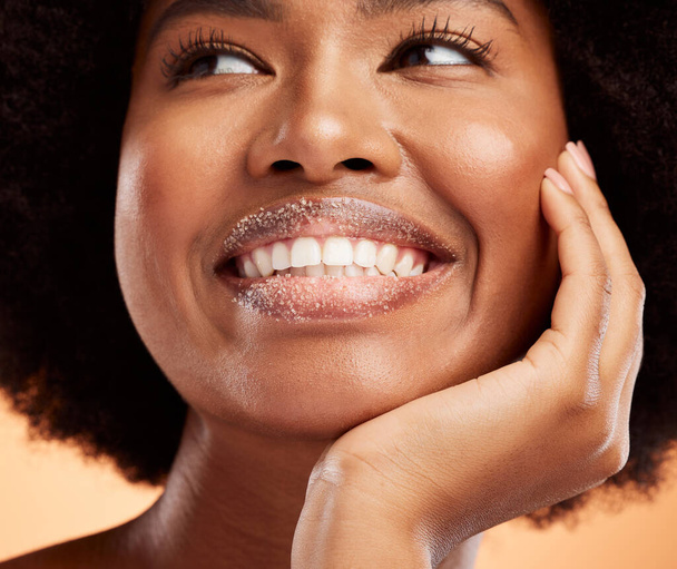 Black woman, lip sugar makeup or skincare health of exfoliate model with smile on orange studio background. Natural healthy, smooth skin and happy with beauty cosmetic hair treatment model. - 写真・画像