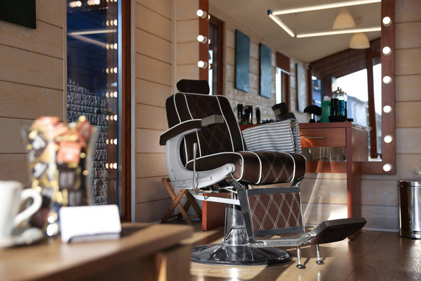 Stylish hairdresser's workplace with professional armchair in barbershop - 写真・画像