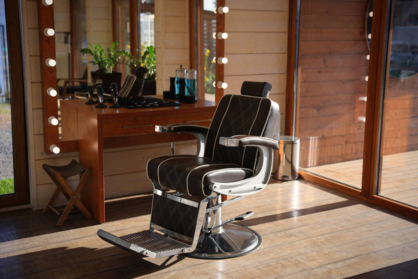 Local de trabalho elegante cabeleireiro com poltrona profissional e grande espelho na barbearia. Design de interiores - Foto, Imagem