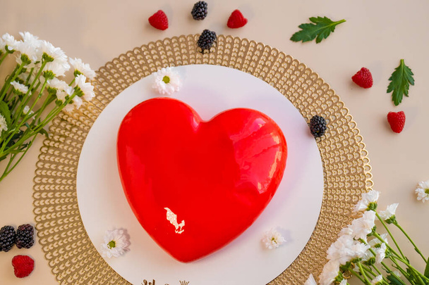 Valentines Day dessert.Mousse Cakes.Heart cake.Red heart cake and white daisies. wedding dessert cake with berries and chamomile flowers.Cake for a loved one.Baked goods and desserts  - Фото, изображение