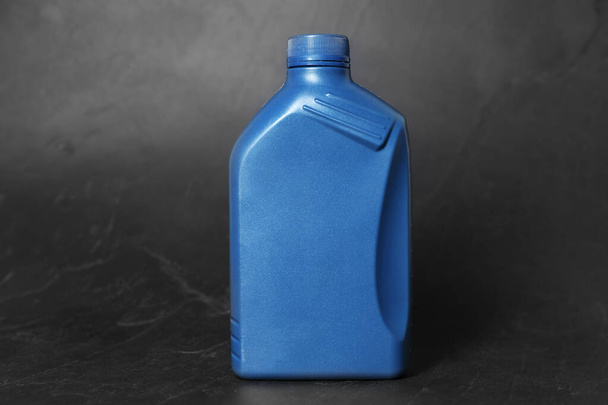 Motor oil in blue canister on black background - Фото, зображення