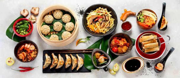 Assorted Chinese food on dark background. Chinese cuisine dishes on table. Asian food concept. Top view. - Photo, image