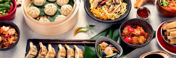 Assorted Chinese food on dark background. Chinese cuisine dishes on table. Asian food concept. Panorama, banner - Foto, immagini