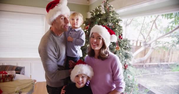 Πορτρέτο μιας ευτυχισμένης καυκάσιας οικογένειας που στέκεται μπροστά από ένα χριστουγεννιάτικο δέντρο - Πλάνα, βίντεο