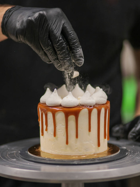 cake ontwerper op het werk met een cupcake - Foto, afbeelding