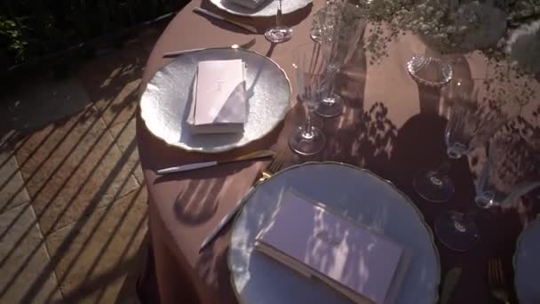 Κάρτες ονομάτων σε πιάτα κοντά σε μπουκέτο λουλουδιών σε ένα στρωμένο τραπέζι. Στο πάνω μέρος. Υψηλής ποιότητας υλικό FullHD - Πλάνα, βίντεο