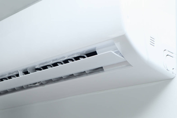 Air conditioner on white wall background. Split air conditioner on a white wall. Closeup image electric equipment in house. - Photo, Image