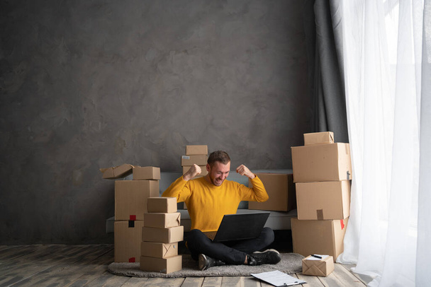 Startup small business entrepreneur SME or freelance handsome man using a laptop with box at home, happy success man with her hands lift up, online marketing packaging box and delivery, SME concept. - Valokuva, kuva
