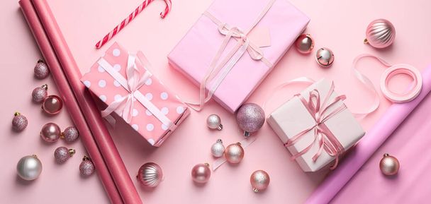 Красивые подарочные коробки на Рождество и декор на розовом фоне, вид сверху - Фото, изображение