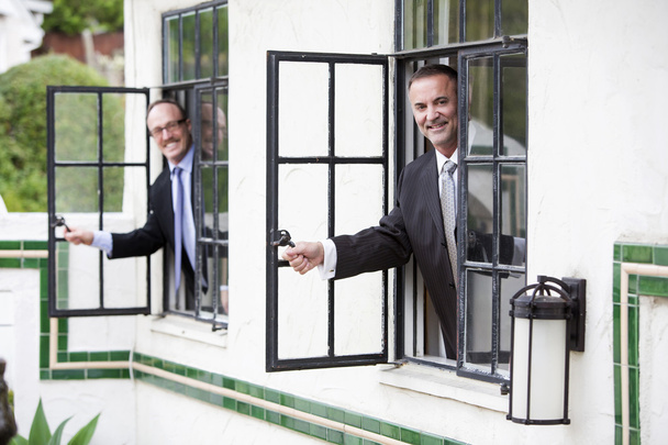 δύο επιχειρηματίες αναζητούν έξω από ένα παράθυρο - Φωτογραφία, εικόνα