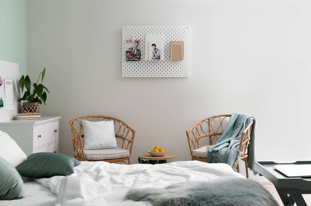 Pohodlná postel, křesla a pegboard v světlé místnosti interiér - Fotografie, Obrázek