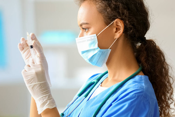 Doctora en máscara médica con jeringa en el hospital, primer plano - Foto, Imagen