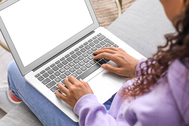 Mujer joven usando el ordenador portátil en el sofá en casa, primer plano - Foto, imagen