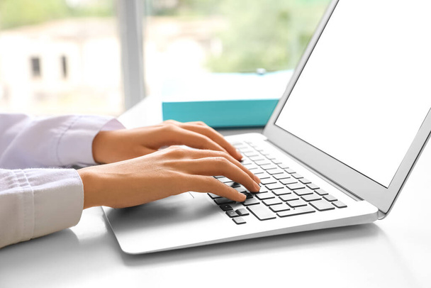Jovem mulher usando laptop na mesa no escritório, close-up - Foto, Imagem