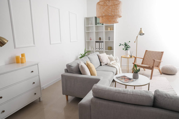 Interno di soggiorno luminoso con divani grigi, tavolo e scaffale - Foto, immagini