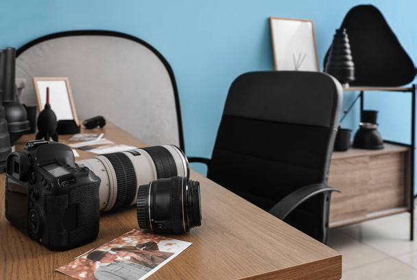 Professional photo camera and picture on table in studio, closeup - Photo, Image
