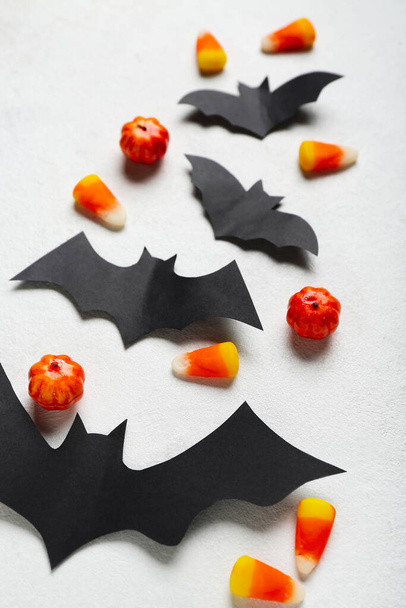 Halloween decor met papieren vleermuizen op lichte achtergrond, close-up - Foto, afbeelding