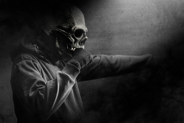 Man with a skull head costume standing in the dark. Halloween concept - Valokuva, kuva