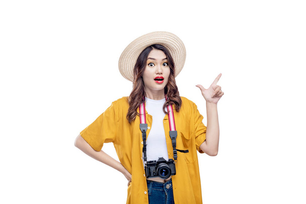Ázsiai nő egy kalap és kamera mutat valamit elszigetelt fehér háttér - Fotó, kép