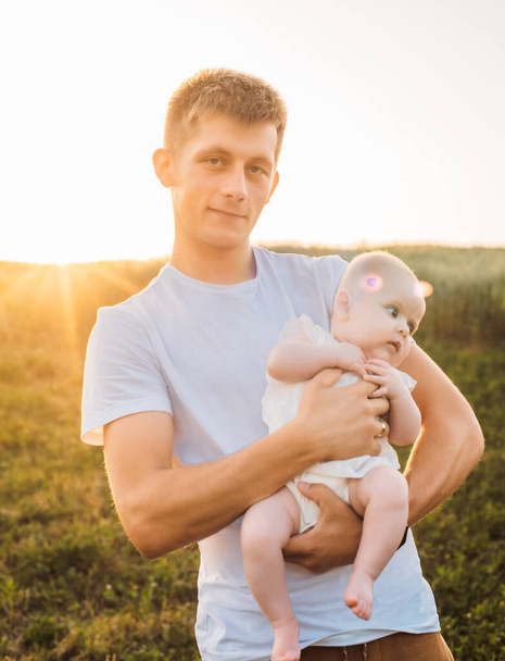 father and daughter posing outdoors in the field. Playing and having fun with little baby . Happy family concept - Photo, Image