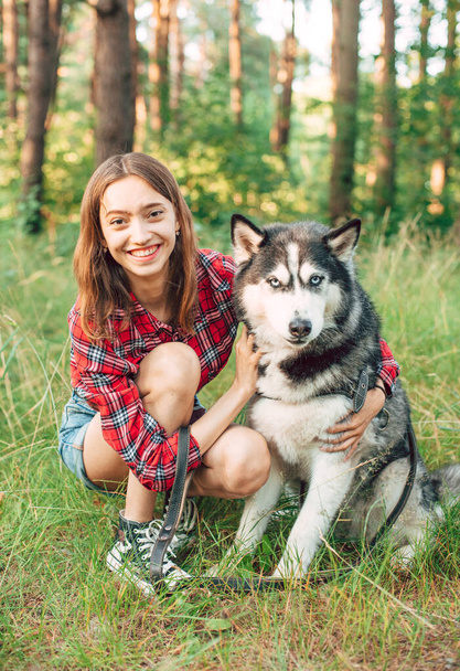 teenage girl playing and having fun with her siberian husky dog. Girl with dog in the forest - Photo, Image