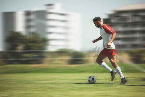Football, fitness and soccer player running on the field to score goals in a sports match or training game outdoors. Blur, Brazil and young athlete doing cardio exercise, practice or workout on grass. - Foto, immagini